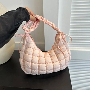 Pink quilted half-moon shoulder bag with ruched handle and bow accents for women