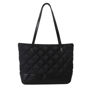 Large black quilted tote bag with faux leather trim and spacious interior design