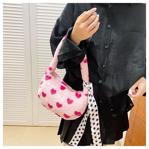 Detail of pink plush heart handbag with black and white polka dot scarf handle