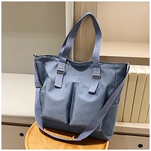 Close-up of blue canvas tote bag on a wooden tray with a warm bookshelf background