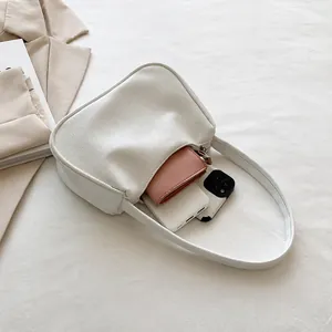 Geräumiges Innenfach der weißen Schultertasche mit Platz für Smartphone und Geldbörse