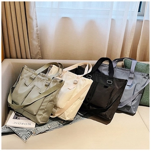 Close-up of four canvas tote bags with functional pockets in green, beige, black, and blue