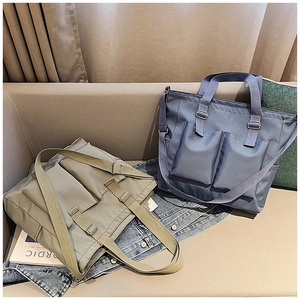 Detail of waterproof nylon tote bags showing large front pockets and adjustable straps