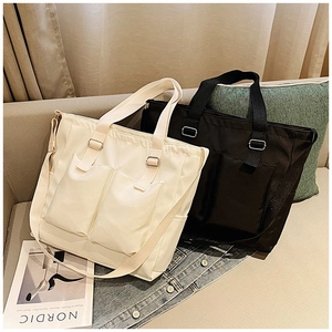 Detail of canvas tote bags with dual handles, adjustable straps and front pockets