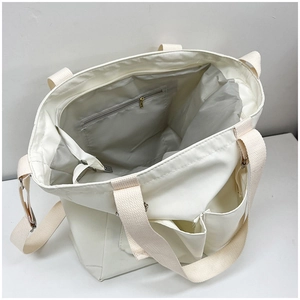 Interior view of cream canvas tote bag showing spacious storage and grey zipper pocket