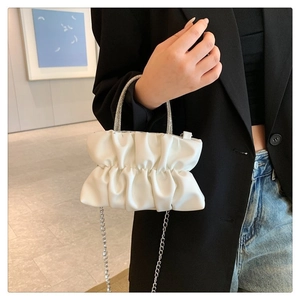 Gros plan du sac nuage plissé blanc avec poignée en strass et chaîne argentée
