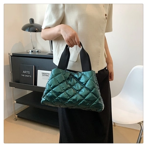Vue détaillée du sac matelassé vert foncé avec motif à losanges et larges bandoulières