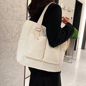 White multi-pocket canvas tote bag with adjustable shoulder strap for women
