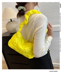 Detail der neongelben Stepp-Cloud-Tasche mit geriffeltem Trageriemen als Achseltasche
