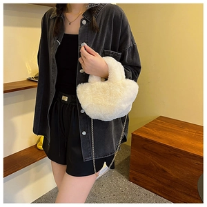 Detalle del bolso de peluche blanco con cadena de metal dorado usado por la modelo