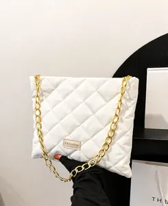 Close-up of white quilted bucket bag featuring a gold chain strap and FASHION label
