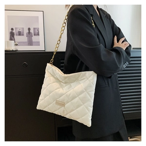 Close-up of off-white quilted shoulder bag with gold chain strap and fashion label detail