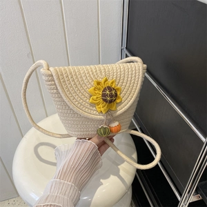 Handmade woven crossbody bag in creamy white with a vibrant sunflower and colorful charms