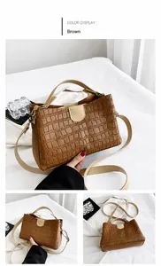 Close-up of brown crocodile texture handbag with contrasting clasp and top handle