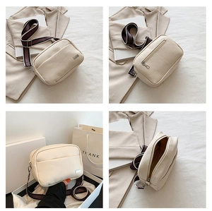 Detail of lychee textured PU leather camera bag with a wide striped fabric shoulder strap