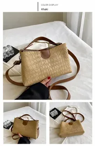 Detail view of khaki faux leather tote bag with crocodile texture and brown straps