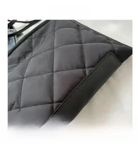 Close-up of black quilted oxford fabric detail with elegant diamond stitching and leather trim