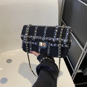 Elegante tweed schoudertas met blauw-zwart ruitpatroon en gouden draaisluiting metalen
