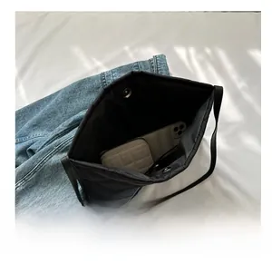 Interior view showing the large capacity of a black quilted tote bag with a long wallet