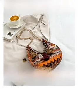 Detail of bohemian woven crescent bag with colorful fringe tassels and chain strap
