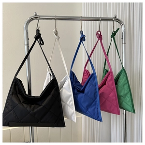 Quilted crossbody bags in five colors hanging on metal hooks with knot strap details