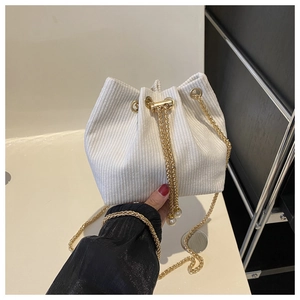 Detail der weißen Cord-Beuteltasche mit Kordelzug und goldener Ketten-Schulterriemen