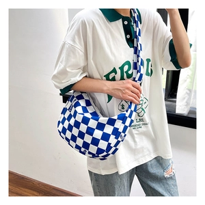 Détail du sac demi-lune en toile à damier bleu avec texte mode et bandoulière