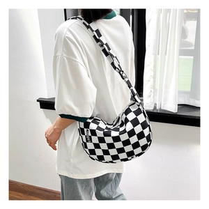 Détail de la bandoulière en toile à damier avec texte FASHION et texture de tissu tissé