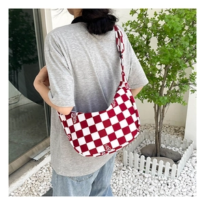 Sac bandoulière en toile à damier rouge et blanc avec logo Fashion porté en extérieur