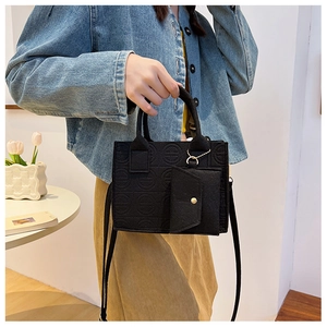 Detail of black felt tote bag with circular embossed texture and matching mini coin purse