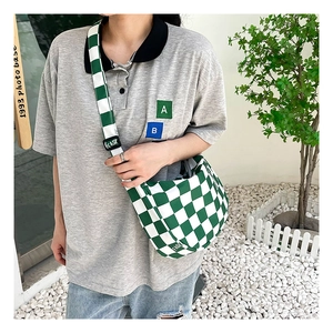Sac bandoulière en toile à damier vert et blanc porté avec une tenue décontractée