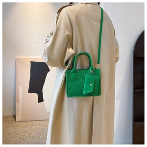 Detail view of green felt crossbody bag with quilted pattern and small matching coin purse