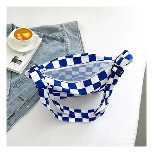 Détail du sac bandoulière à damier bleu avec fermeture éclair et sangle réglable