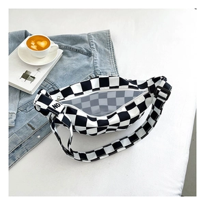 Détail du sac à carreaux avec bandoulière réglable et sangle décorative avec lettres NO