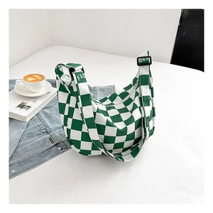 Détail du sac bandoulière à damier vert avec forme en demi-lune et large bandoulière