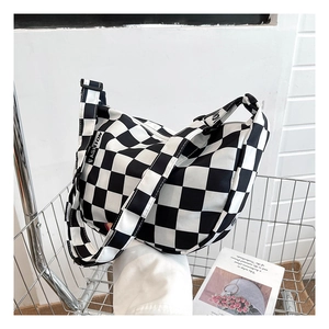 Détail du sac en toile à damier dans un caddy montrant l'étiquette de la sangle