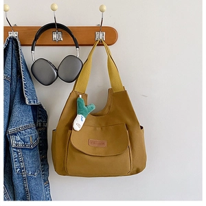 Détail du sac cabas en toile gingembre avec poche avant et pendentif en peluche oignon