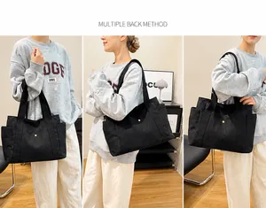 Detalle del bolso tote de lona con correa ajustable y herrajes metálicos