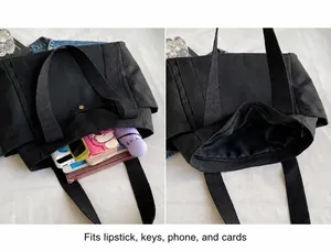 Detalle del bolso tote de lona negra con botón de presión y gran capacidad de almacenaje