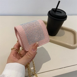 Pink mini chain bag with colorful rhinestones held in hand for a stylish summer look
