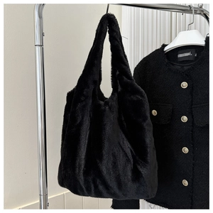 Détail d'un cabas noir en peluche suspendu avec une veste d'hiver assortie
