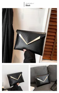 Dettaglio della borsa a bustina nera con trapuntatura a V e finiture in metallo dorato