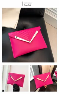 Dettaglio della pochette trapuntata rosso rosa con finiture in metallo dorato a forma di V