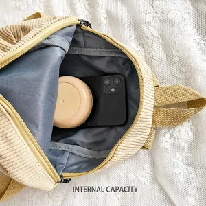 Detail view of corduroy backpack interior showing storage for phone and cosmetics