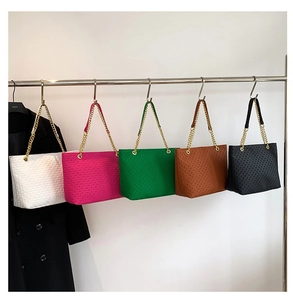 Dettaglio di borse tote in cinque colori con goffratura geometrica e catene dorate