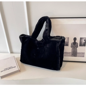 Détail d'un sac cabas en fausse fourrure noire montrant la texture douce et la grande capacité