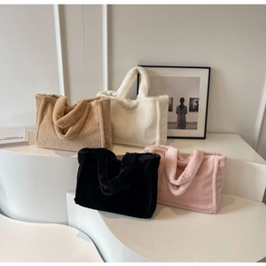 Grands sacs cabas en peluche en camel, crème, noir et rose sur des marches blanches