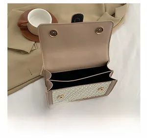 Vue intérieure du sac à main beige tressé avec double compartiment et fermoirs aimantés dorés