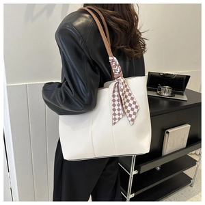 Detail der weißen Leder-Tote-Bag mit braunen Riemen und modischem kariertem Seidenschal