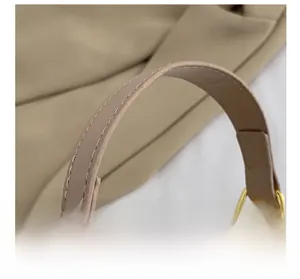 Vue détaillée de la poignée ronde avec boucle en métal doré sur sac tissé